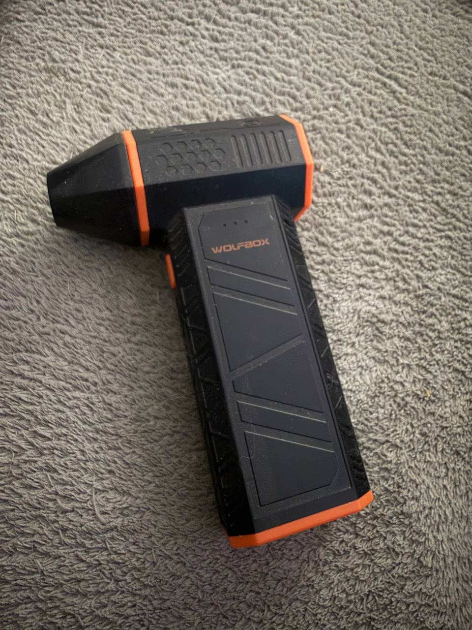 WOLFBOX MF50 cordless air duster in black and orange, showing the pistol grip design and WOLFBOX branding